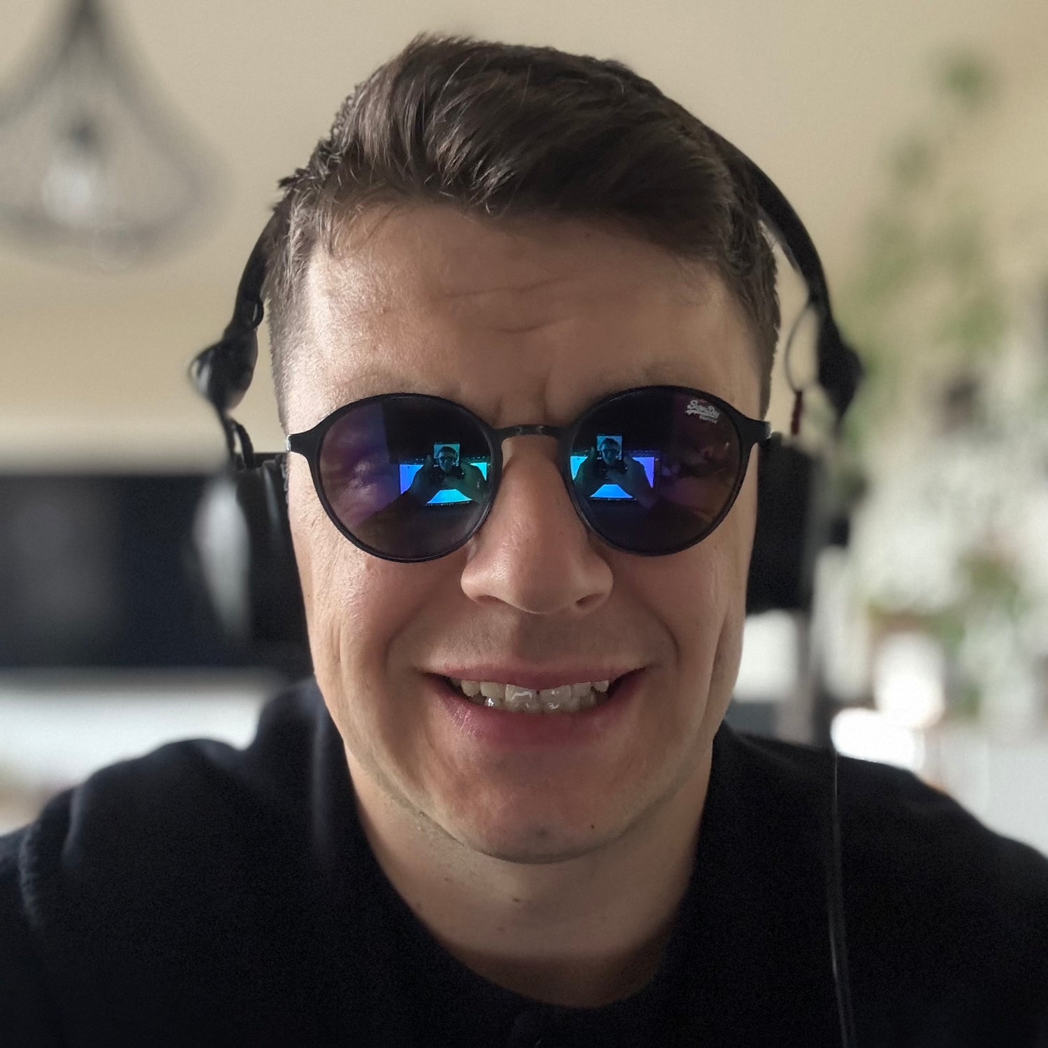 Black View wearing headphones and sunglasses, with the mastering studio reflected in the lenses.
